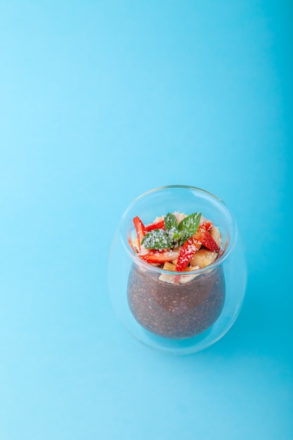 Chocolate Chia pudding decorated with strawberry on blue background