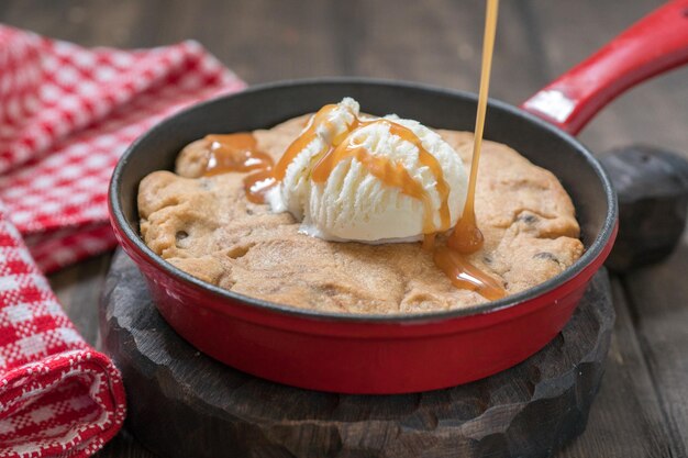 Chocolate chip cookie with ice cream and caramel homemade on a pan