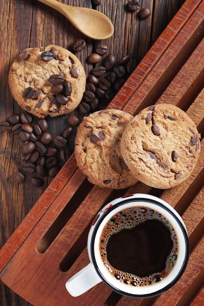 Photo chocolate chip cookies and cup of coffee on wooden table close up top view