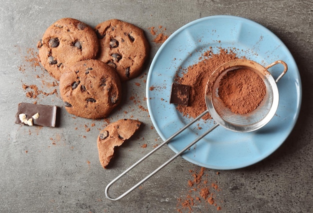 chocolate chip cookies and a cup of tea on dark grey background