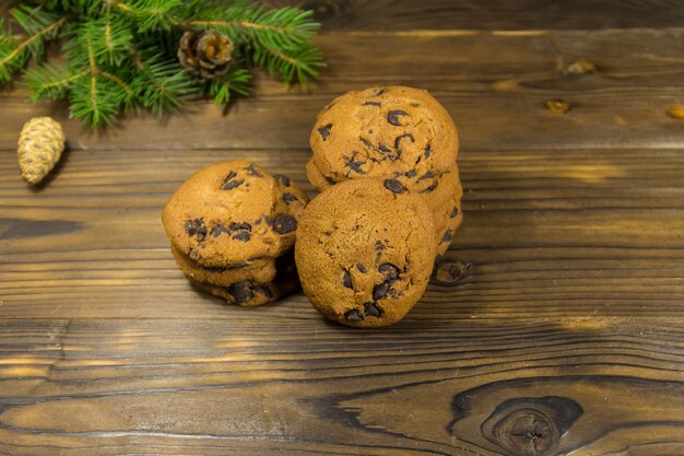 Chocolate chip cookies in front of Christmas decoration on wooden table