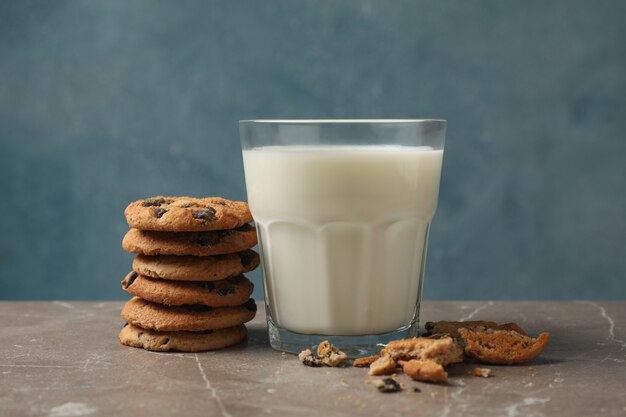 Chocolate chip cookies and glass of milk on brown table