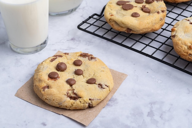 Chocolate chip cookies over marble table with milk