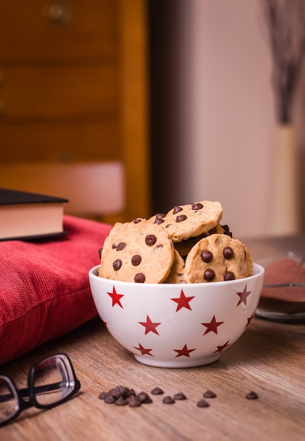 Chocolate chip cookies and milk on wood background