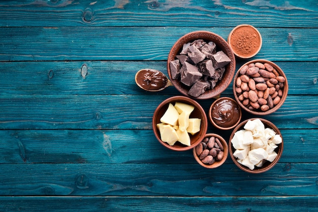 Chocolate cocoa and cocoa beans on a blue wooden background Top view Free copy space