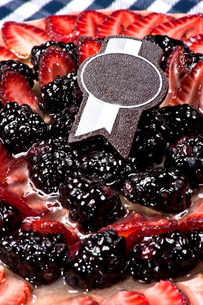 chocolate and coffee cake with strawberries and blackberries with red berries and decorative toppers