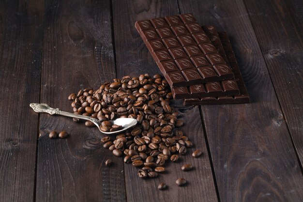 Chocolate and coffee on dark wooden surface