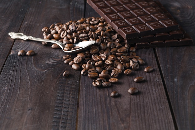 Chocolate and coffee on dark wooden surface