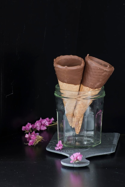 Chocolate cones in a glass jar. Dark background