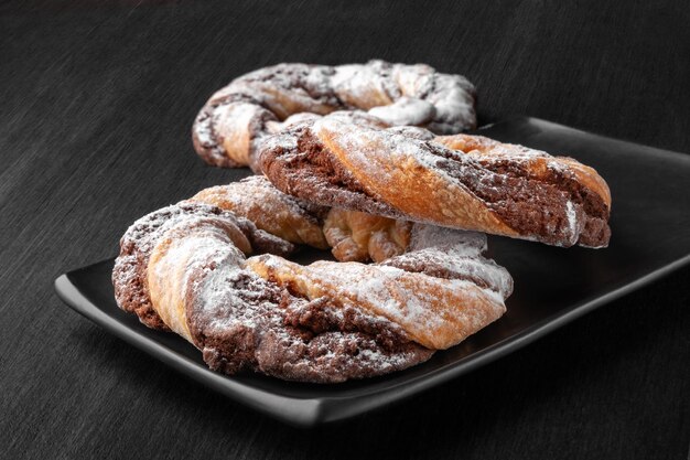 Chocolate cookie rings sprinkled with powdered sugar