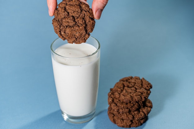 Chocolate cookies biscuit dipped with a glass of milk.