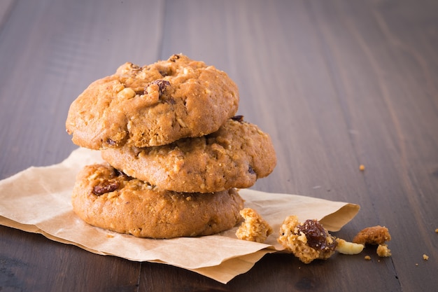 Chocolate Cookies Raisins are stacked three pieces on a wooden floor.