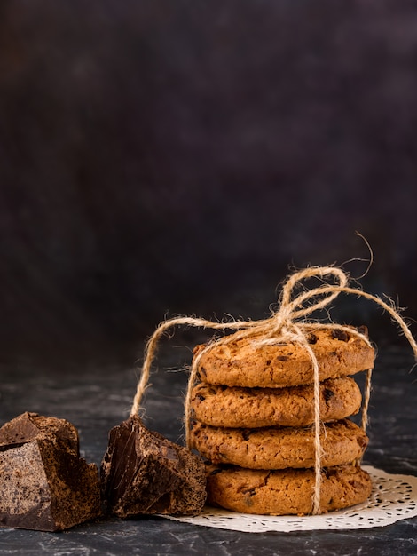 Biscotti al cioccolato, impilati e legati con una corda, pezzi di cioccolato nero