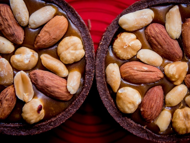 Chocolate cookies with almond nuts on a red plate. Restaurant.