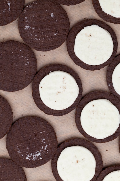 Chocolate cookies with creamy cream filling, divided into pieces of biscuits and cream filling