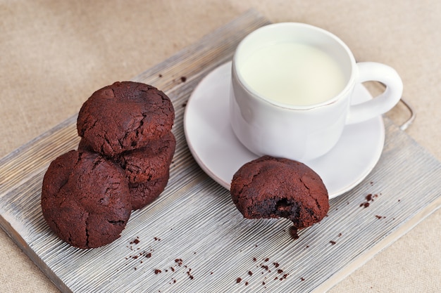 Chocolate cookies with milk on wooden desk