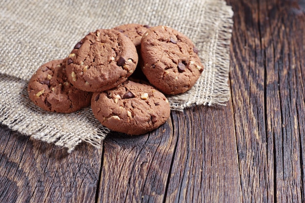 Chocolate cookies with nuts on old wooden table