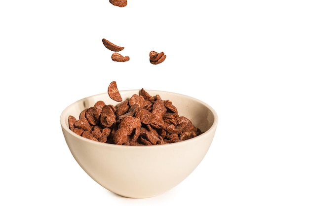 Chocolate corn flakes falling to the white bowl isolated on white Motion Copyspace