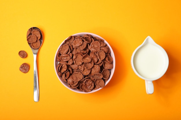 Chocolate cornflakes for breakfast on colored background close up