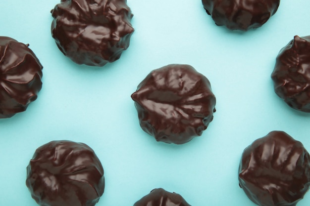 Chocolate covered marshmallows on blue surface