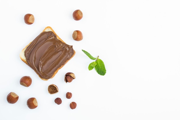 Chocolate cream bread and hazelnuts on the white background Copy space Top view