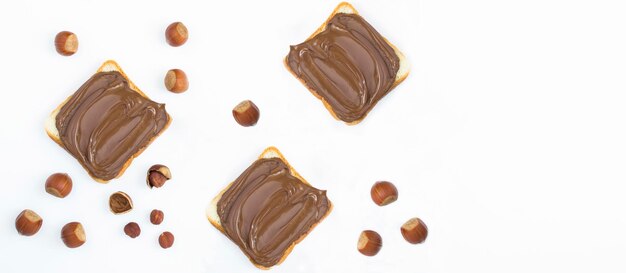 Chocolate cream bread and hazelnuts on the white background. Copy space. Top view.