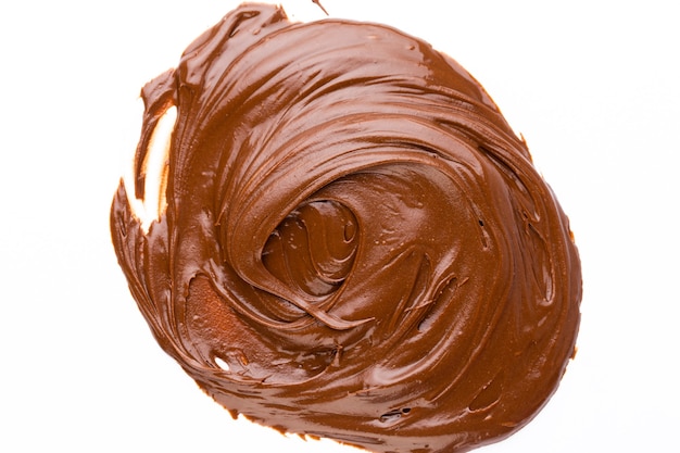 Crema al cioccolato isolata sulla superficie bianca. lay piatto.