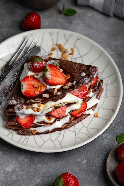 Chocolate crepes with cream cheese and strawberries