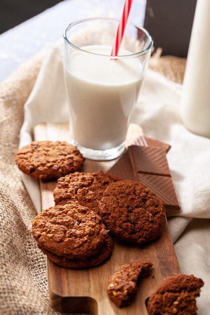 牛乳のガラスとチョコレートクリスピークッキーをクローズアップ