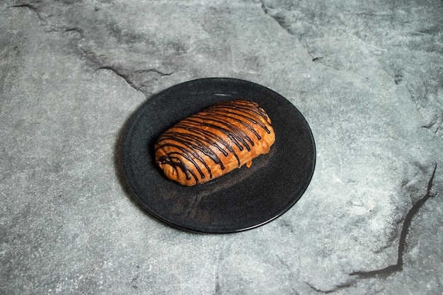 Chocolate croissant served in plate isolated on background top view of baked food indian dessert