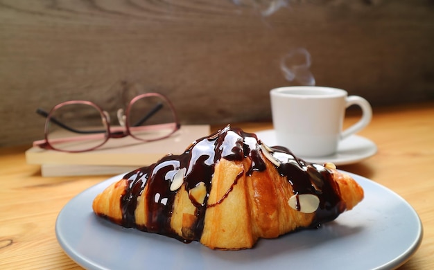 Chocolate Croissant with a Cup of Steaming Coffee in the Backdrop