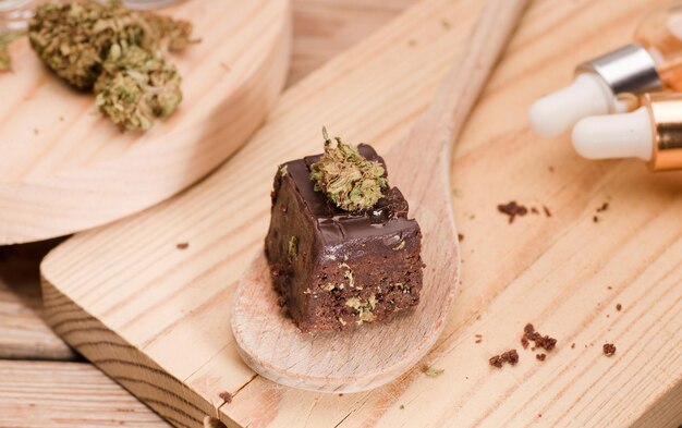 Chocolate cupcake muffins cannabis buds in wooden spoon oil pot and cooking jara Marijuana cake