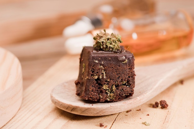 Chocolate cupcake muffins with cannabis buds on wooden spoon Marijuana hemp in food