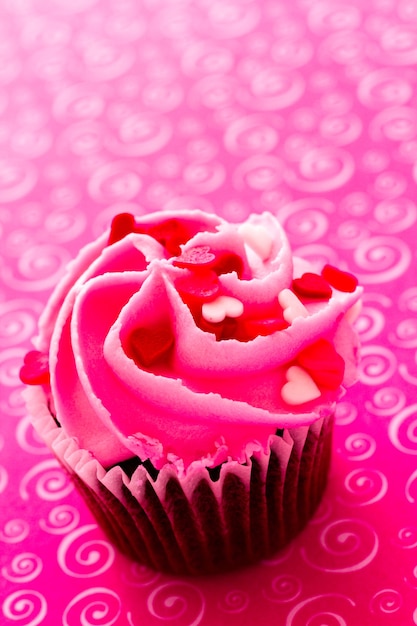 Chocolate cupcake with pink icing decorated for Valentine's Day.