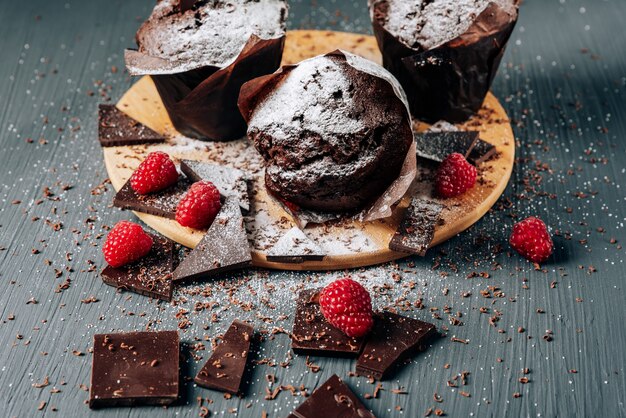 Chocolate cupcakes close up with chocolate and raspberries