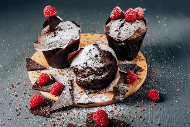 chocolate cupcakes close up with chocolate and raspberries