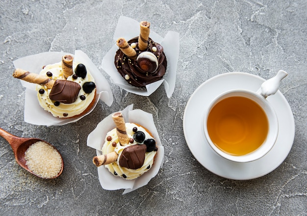 コンクリートのテーブルにチョコレートカップケーキとお茶