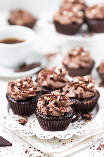 Chocolate cupcakes decorated coffee cheese cream on white plate