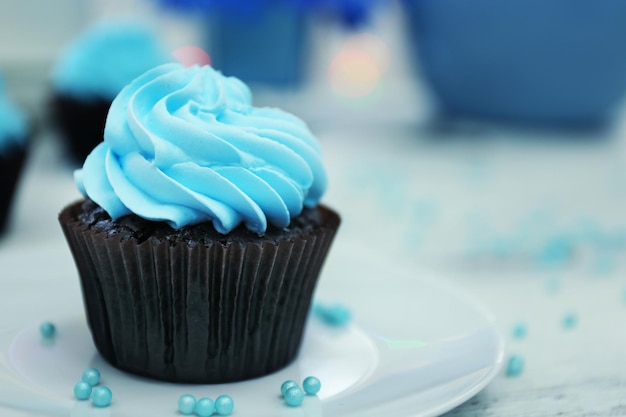 Chocolate cupcakes and flowers on a table