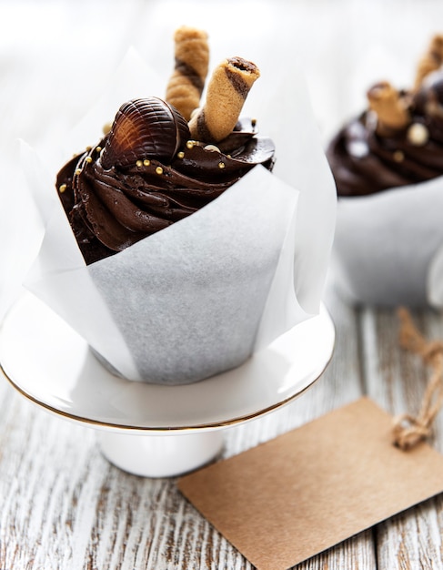 白い木製のテーブルの上のチョコレートカップケーキ