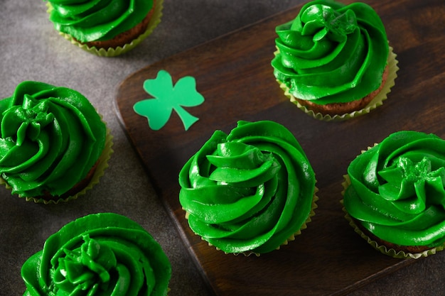 Chocolate cupcakes with green whipped cream and chocolate sprinkles