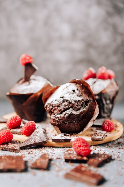 Chocolate cupcakes with raspberries and bitter chocolate close-up