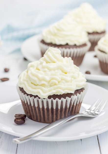 Chocolate cupcakes with ricotta cheese frosting on the white plate