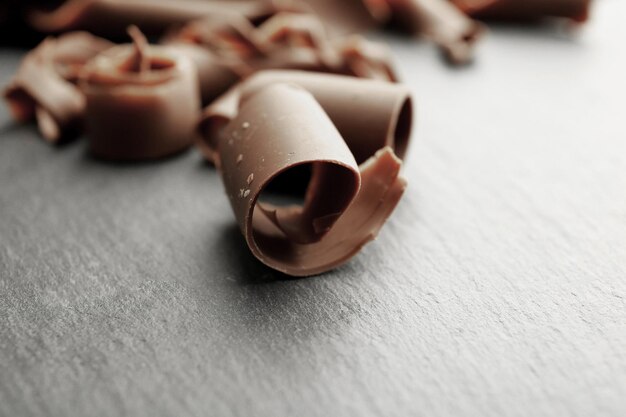 Photo chocolate curls on wooden table close up