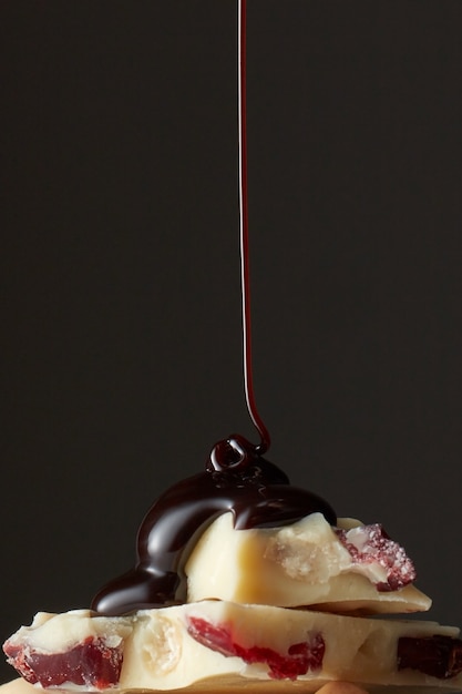 Chocolate cyrop pouring onto a piece of white chocolate