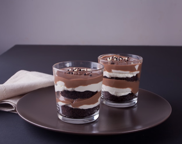 Chocolate dessert in glass jars on a table with stars.