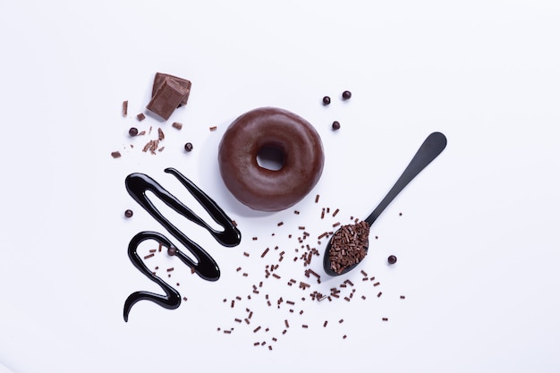 Chocolate donut and chocolate on white background. Top view.