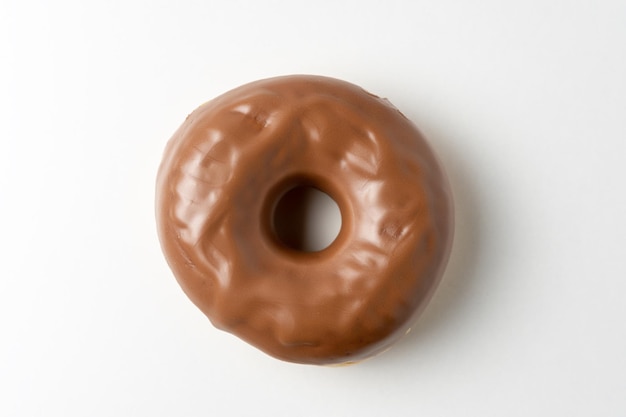 Фото Шоколадный пончик на белом фоне вид сверху