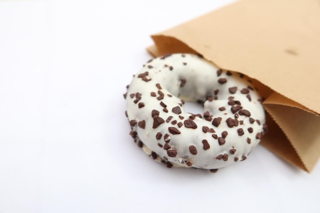 Chocolate donuts in a paper packet on white