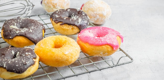 Photo chocolate donuts and pink donuts on the kitchen table